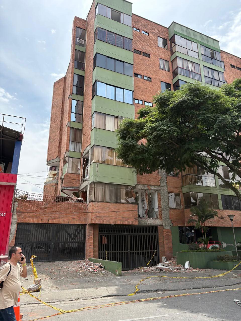 Fachada del edificio con grietas profundas y cinta de peligro