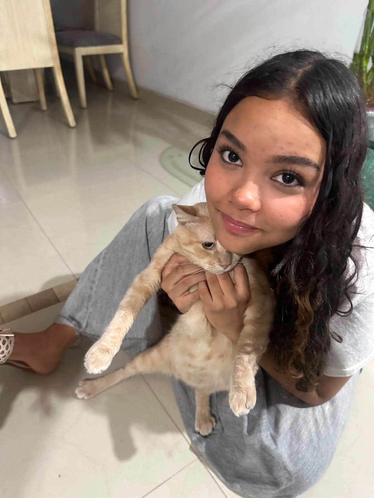 Sara sonriendo con su gato en brazos